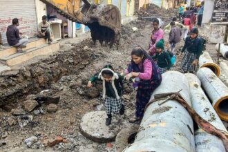 Indore water crisis: School students make their way through the debris amid the pipeline and drainage work undertaken after of deaths caused by consumption of contaminated water in the Bhagirathpura area of Indore, Madhya Pradesh (Photo: PTI)