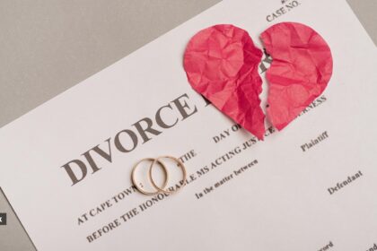 A divorce paper with two engagement rings and a broken paper heart