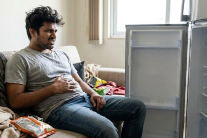 A hangry person sitting in front of an empty fridge
