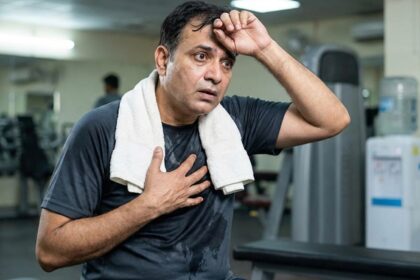 An Indian man after a workout is worried after his heart that suddenly starts racing, with his hand on his heart
