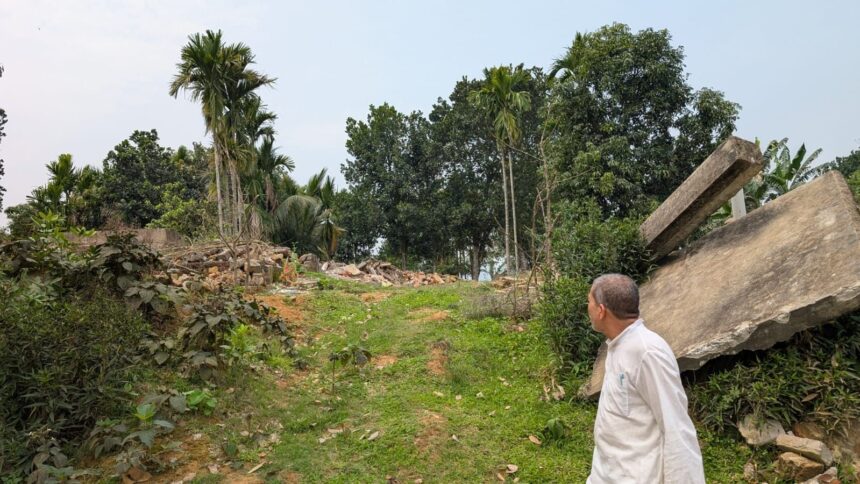 A camp resident, Suleman Ali, near this house in the Hasila Beel wetland area of Assam’s Goalpara district that was demolished during a large-scale eviction drive last June. (Express Photo/Sukrita Baruah)