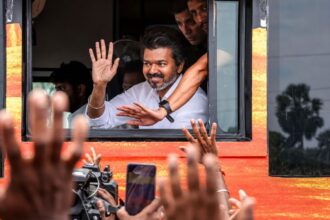 Tamil Nadu Chief Minister Vijay greets supporters during his visit to Karur, where he is scheduled to meet families affected by the 2025 stampede and attend official events. (File Photo/Enhanced using AI)