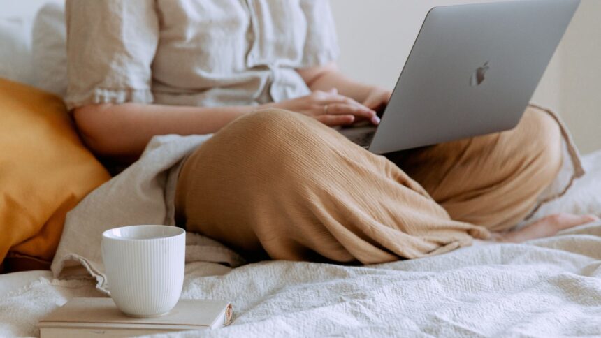 Person working from bed with a laptop at home; what impact does it have on blood sugar