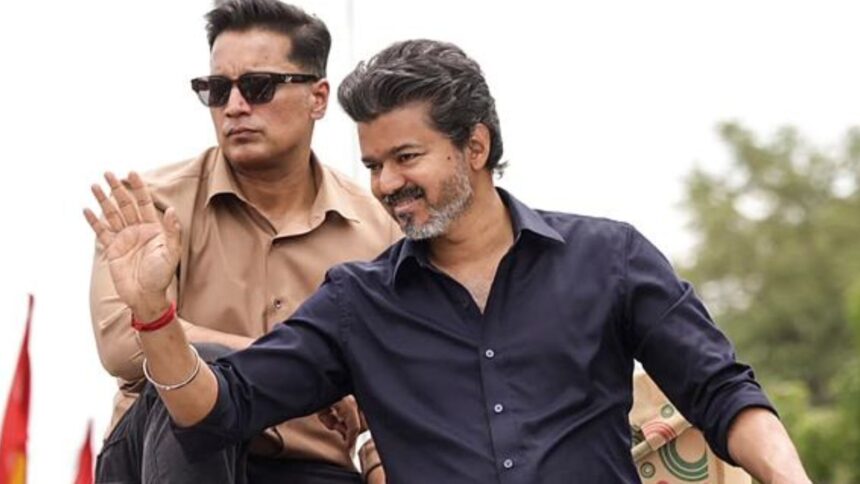 Tamil Nadu Chief Minister Joseph Vijay greets the gathering at a roadshow during his first official visit to Karur after he took up the reins as Chief Minister, in Karur. (@TVKPartyHQ/X via PTI Photo)